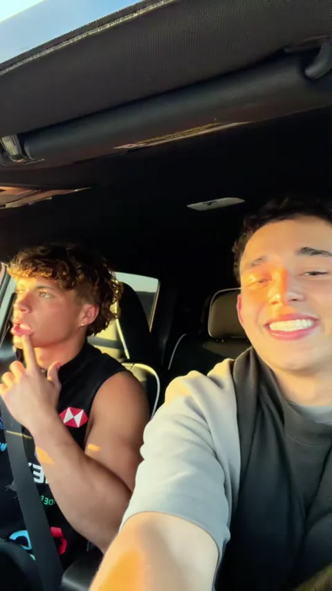 Two friends in a car at golden hour